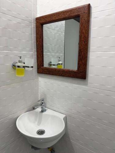 a bathroom with a white sink and a mirror at Nashu House Stone Town in Ngambo