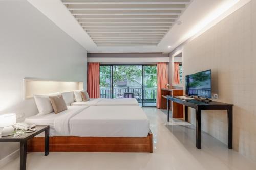 a bedroom with a large bed and a television at Phuvaree Resort in Patong Beach
