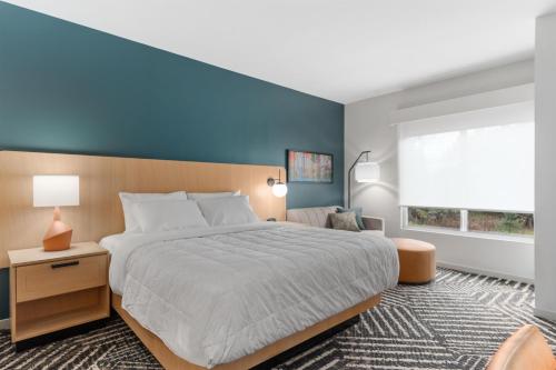 a bedroom with a large bed and a blue wall at Hyatt House Thunder Bay in Thunder Bay