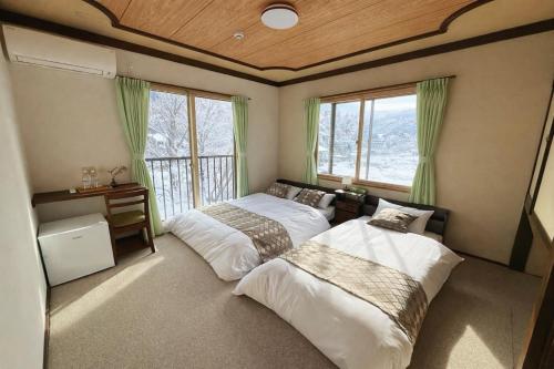 a bedroom with two beds and a window at 雪场缆车站旁-START HOUSE PIAA-Ski IN Ski OUT in Minami Uonuma