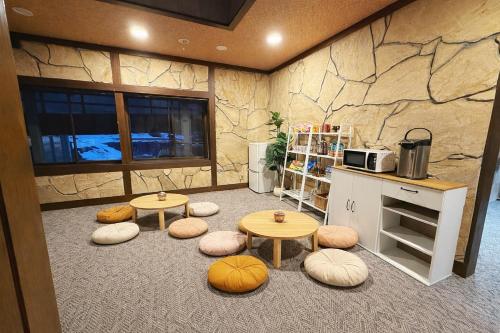 a kitchen with two tables and stools in a room at 雪场缆车站旁-START HOUSE PIAA-Ski IN Ski OUT in Minami Uonuma