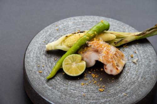 a plate of food with a piece of fish and vegetables at Bettei Amafuru Oka in Ibusuki