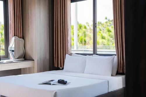 a bedroom with a white bed with a window at ELC Luxury Đà Lạt in Da Lat