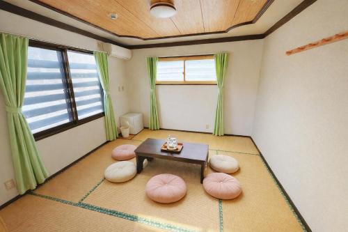 een woonkamer met een tafel en een paar roze stoelen bij 雪场缆车站旁-START HOUSE PIAA-Ski IN Ski OUT in Minami Uonuma