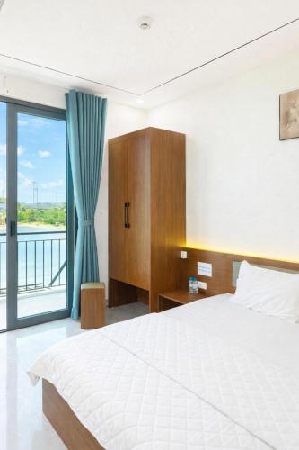 a bedroom with a bed and a large window at 72M Hotel Visip in Vinh