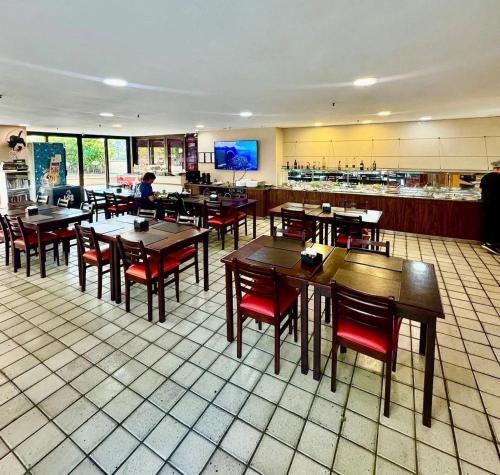 een restaurant met houten tafels en stoelen en een keuken bij Condomínio Four Seasons Residence Service in Rio de Janeiro