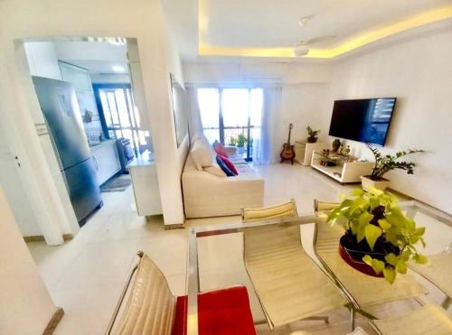een woonkamer met een bank en een tv bij Condomínio Four Seasons Residence Service in Rio de Janeiro