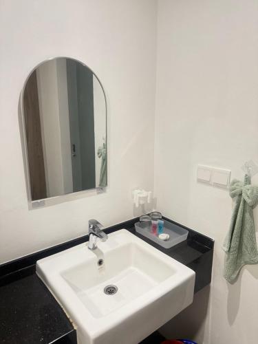 a bathroom with a white sink and a mirror at AbahHomeStudio Tunjung in Kota Bharu