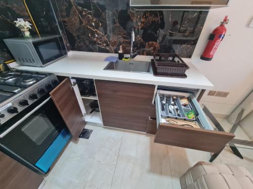 a kitchen with a sink and a stove at Fully Equipped Home near Miracle & Butterfly Gardens in Dubai