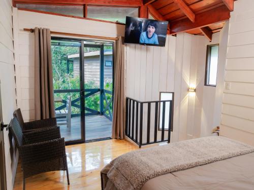 een slaapkamer met een bed en een televisie aan de muur bij Nido de Montaña in Fraijanes