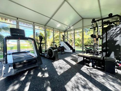 a room with a gym with a treadmill and a simulator at Khaolak Alisa House in Khao Lak