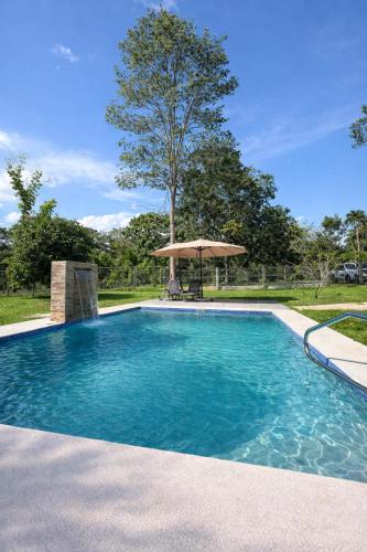 piscina con ombrellone e tavolo di Villa en la naturaleza 