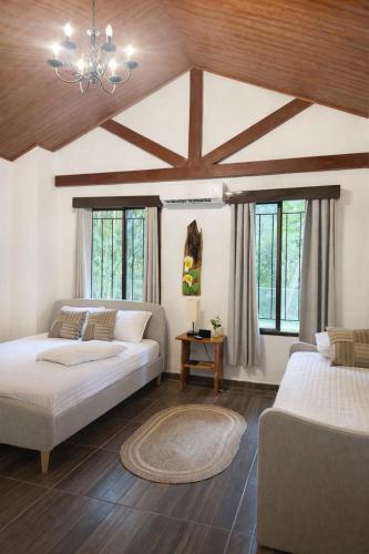 un soggiorno con 2 letti e un lampadario a braccio di Villa en la naturaleza 