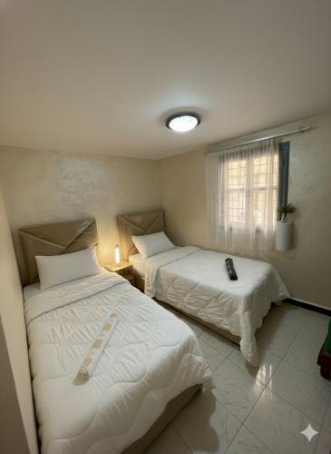 a room with two beds and a window at Entire Guesthouse with Private Rooftop in Taghazout