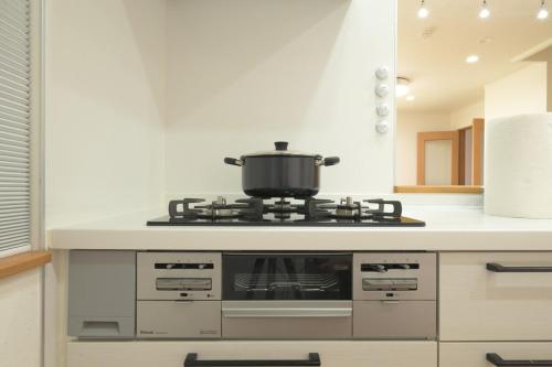a kitchen with a stove with a pot on it at Peace and Harmony House Rongsheng in Nagoya