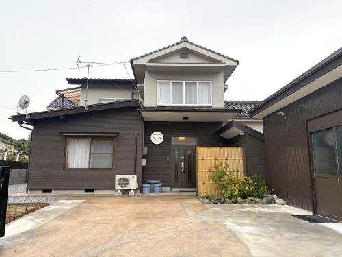 a black house with a driveway in front of it at 松江の里東津田店 in Matsue