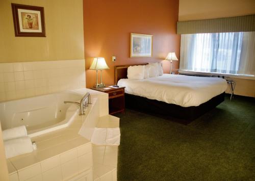een hotelkamer met een bed en een bad bij Hotel Mead Resorts & Conventions Center in Wisconsin Rapids
