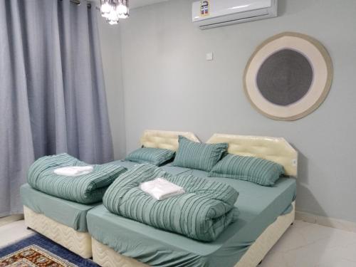 ein Bett mit Kissen darauf in einem Zimmer in der Unterkunft Blue star inn in Al Hamra