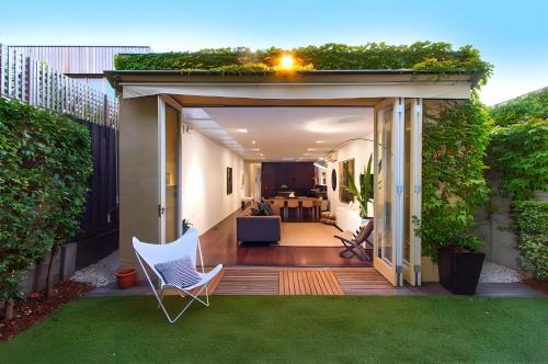a garden with a pergola and chairs on a patio at St Kilda Style - Stunning 3 Bedroom House in Melbourne