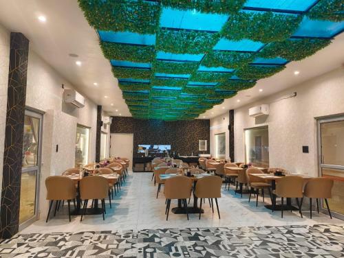 un comedor con mesas, sillas y luces azules en Hotel Omkar Palace, en Ayodhya