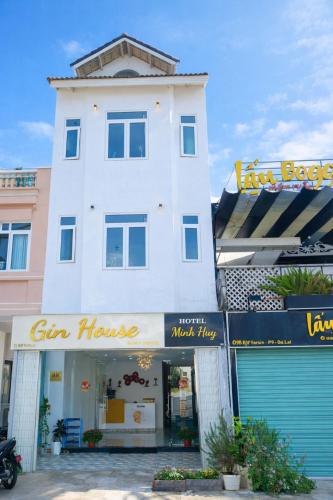 a tall white building with a sign on it at Gin House Đà Lạt in Da Lat