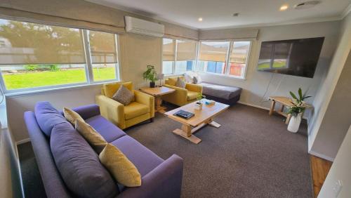 a living room with a couch and chairs and a table at Carramar Motor Inn in Palmerston North