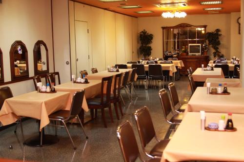 a dining room filled with tables and chairs at Hotel Los Inn Kochi in Kochi