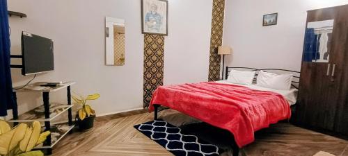 une chambre avec un lit avec une couverture rouge dans l'établissement GS Home on the Bay - Sea view room, à Vagator