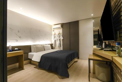 a hotel room with a bed and a television at The Lime Hotel in Incheon