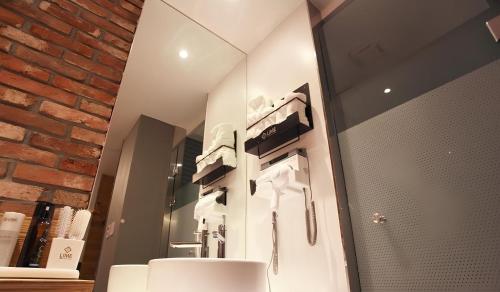 a bathroom with a white sink and a brick wall at The Lime Hotel in Incheon