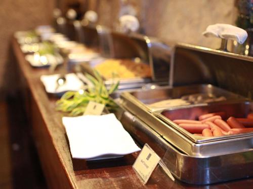 a buffet line with many trays of food at Novotel Lombok Resort & Villas in Kuta Lombok