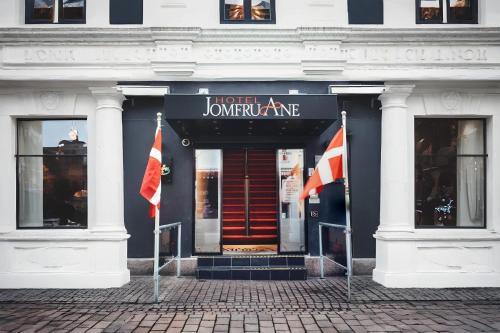 a building with two flags in front of it at Dancenter Hotel Jomfru Ane in Aalborg