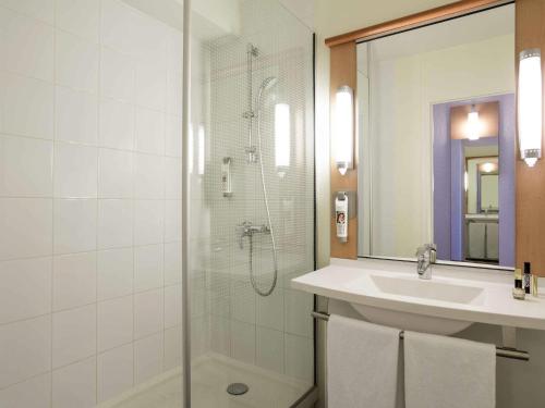 a bathroom with a shower and a sink and a mirror at ibis Montpellier Centre Comedie in Montpellier