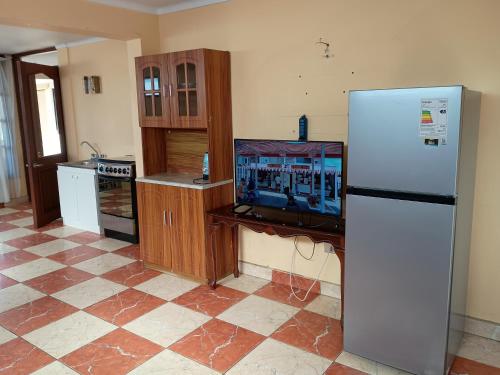 una cucina con frigorifero e TV di Nuestro rincón a Iquique