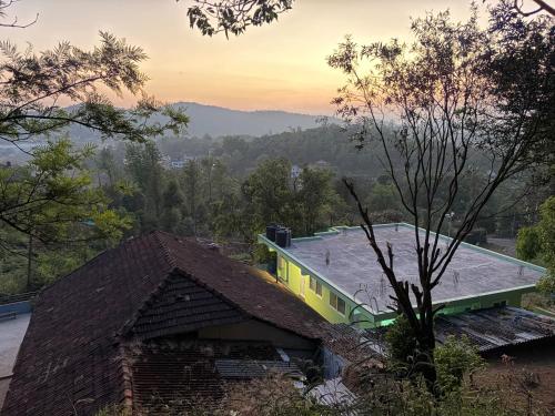 een uitzicht op een huis met een dak bij The Town Cascade in Madikeri