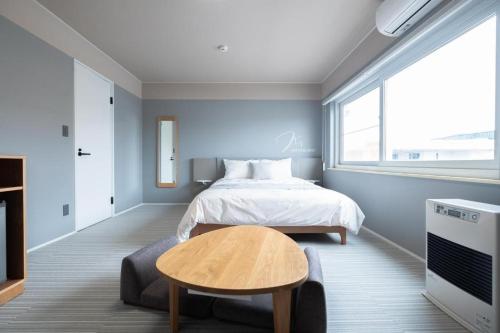 a bedroom with a bed and a table and a tv at B cycle ダブルルーム in Biei