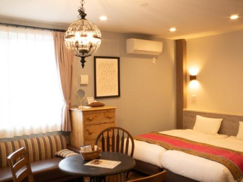 a hotel room with a bed and a table and a desk at 7 Rooms Hotel & Cafe - 推し活応援 プロジェクター貸出有 ディズニーまでバス1本 in Tokyo