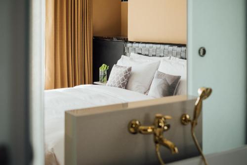 a bedroom with a bed with white sheets and pillows at Chez Nous in Taipei