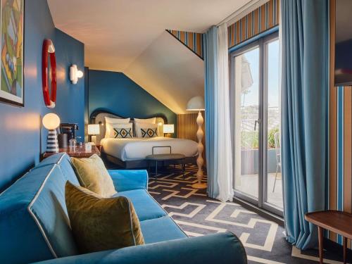 une chambre d'hôtel avec un lit et un canapé dans l'établissement Mercure Paris Butte Montmartre Basilique, à Paris