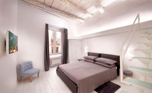 een slaapkamer met een bed en een blauwe stoel bij Bianca Dimora in Cagliari