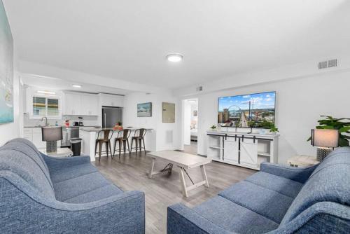 een woonkamer met twee blauwe banken en een keuken bij Oceanview Azul 2BR • Bright Top-Floor Condo in Myrtle Beach