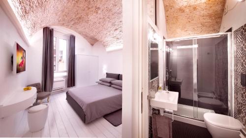 a bedroom with a bed and a bathroom with a sink at Bianca Dimora in Cagliari