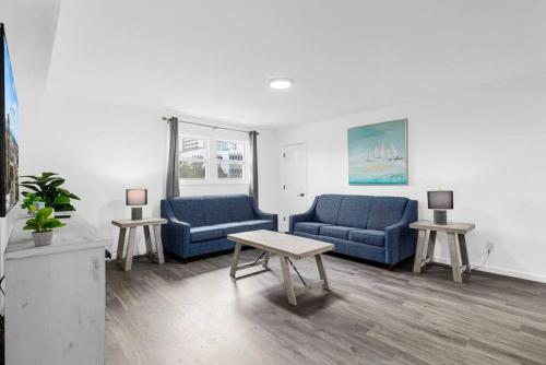een woonkamer met twee blauwe banken en een tafel bij Oceanview Azul 2BR • Bright Top-Floor Condo in Myrtle Beach