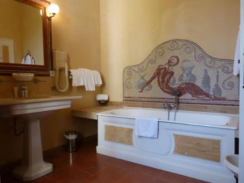 y baño con bañera, lavabo y espejo. en Château d'Arpaillargues - TERITORIA, en Arpaillargues-et-Aureillac