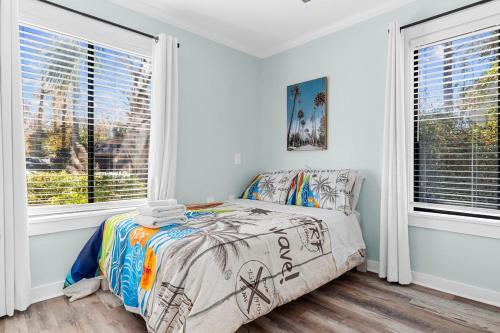 a bedroom with a bed and two windows at Relax: Private Pool Grill Fire Pit in Myrtle Beach