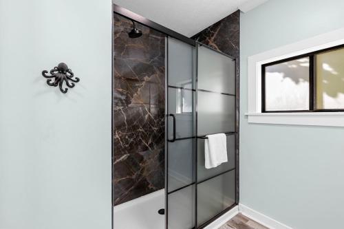 a shower with a glass door next to a window at Relax: Private Pool Grill Fire Pit in Myrtle Beach