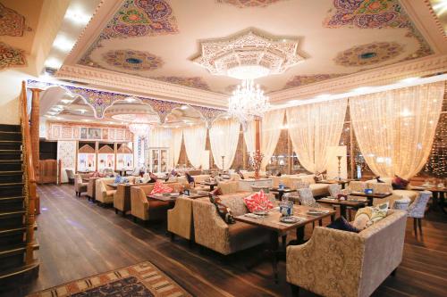 restauracja z kanapami, stołami i żyrandolem w obiekcie Hotel Silk Way w Petersburgu