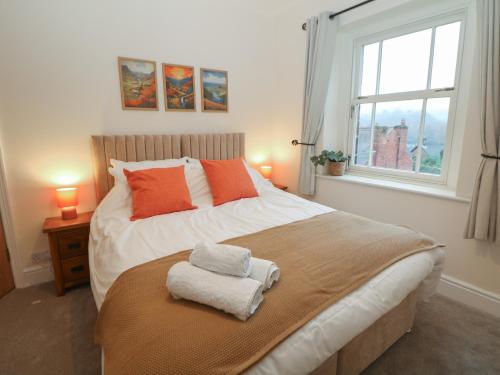 a bedroom with a large bed with a window at Dorset Villas in Matlock