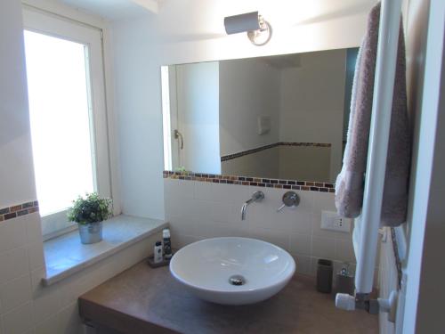 ein Badezimmer mit einem weißen Waschbecken und einem Spiegel in der Unterkunft Appartamento Alloro 2 in Palermo