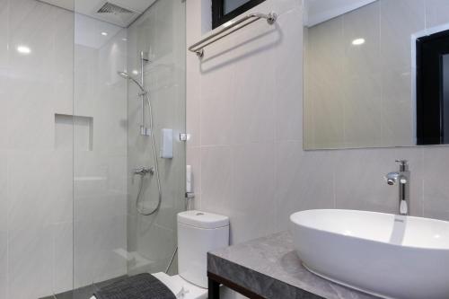un bagno con lavandino, doccia e WC di Vibes Djanti Residence Yogyakarta By Sans Hotel a Demangan